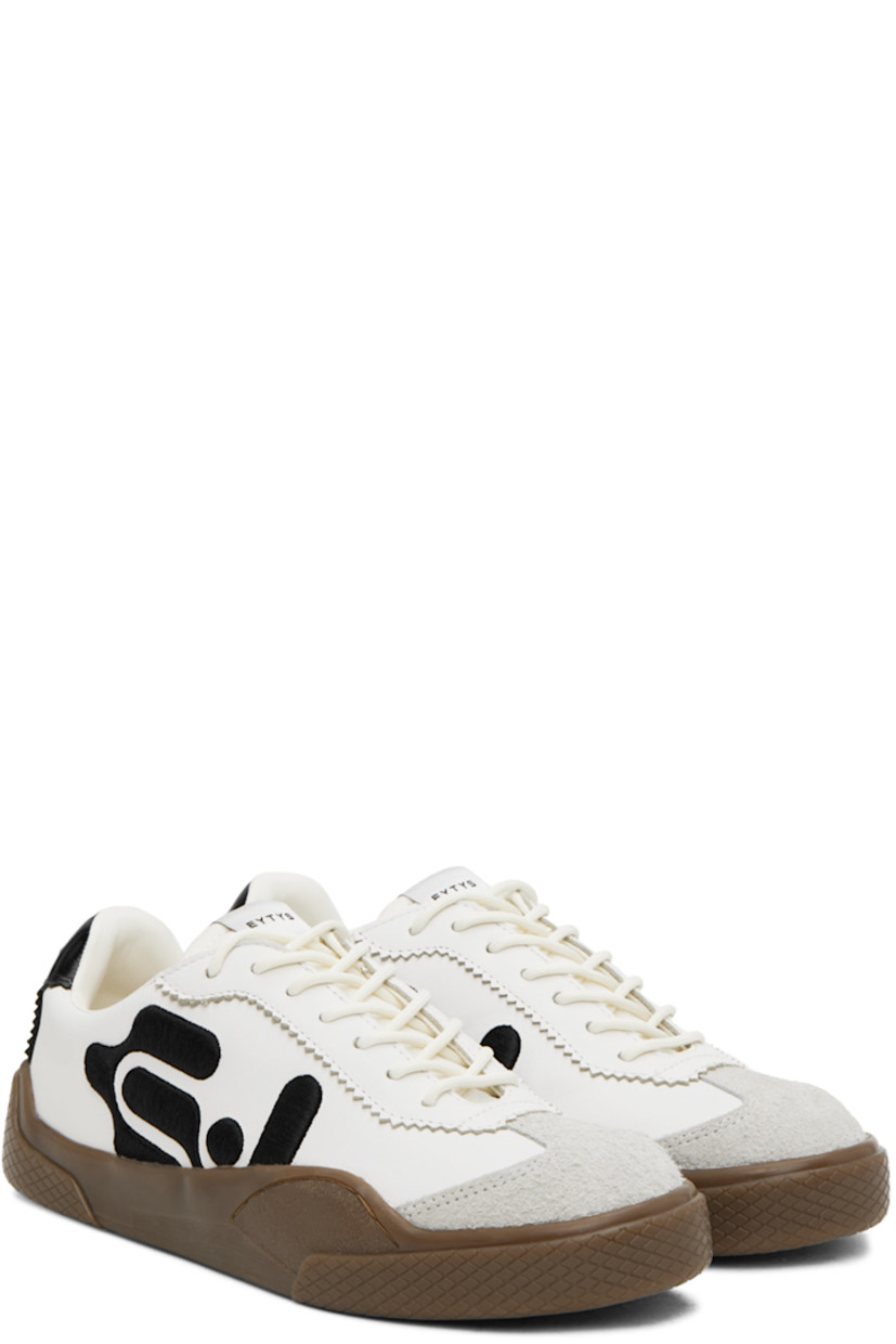 Low-top nappa leather sneakers in white. 

· Serrated edges throughout
· Suede cap toe
· Lace-up closure
· Logo patch at padded tongue
· Padded collar
· Logo embroidered at sides
· Eyelets at inner side
· Text embroidered at heel tab
· Logo embossed at heel
�· Treaded rubber sole

Supplier color: Swan