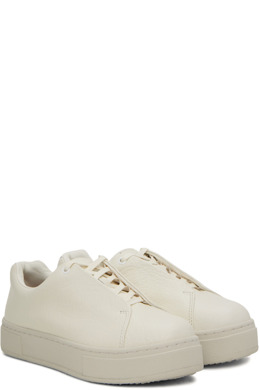 Low-top grained leather sneakers in off-white. 

· Lace-up closure
· Logo patch at padded tongue
· Padded collar
· Eyelets at inner side
· Webbing trim at heel
· Buffed leather lining
· Rubber platform midsole
· Treaded rubber sole

Supplier color: Tumbled white