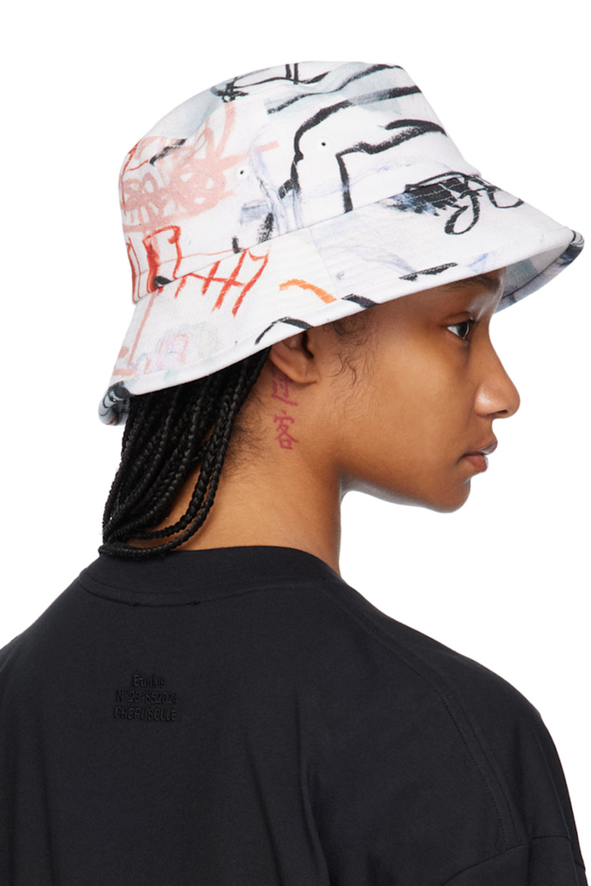 Cotton twill bucket hat in white. 

· Graphic printed throughout
· Eyelets at crown
· Logo hardware at face
· Quilted brim
· Canvas lining

Featuring artwork by Julian Farade.

Supplier color: Ciel de mai