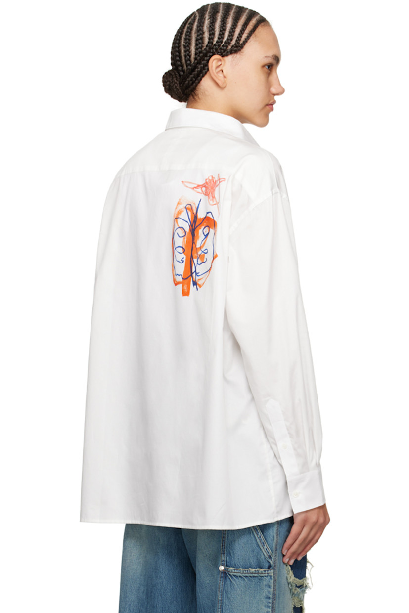 Organic cotton poplin shirt.

· Spread collar
· Button closure
· Graphics printed at front and back
· Logo-engraved silver-tone hardware at front
· Droptail hem
· Dropped shoulders
· Adjustable single-button barrel cuffs
· Pleats at cuffs

Part of the Études x Julian Farade collaboration.

Supplier color: Ete