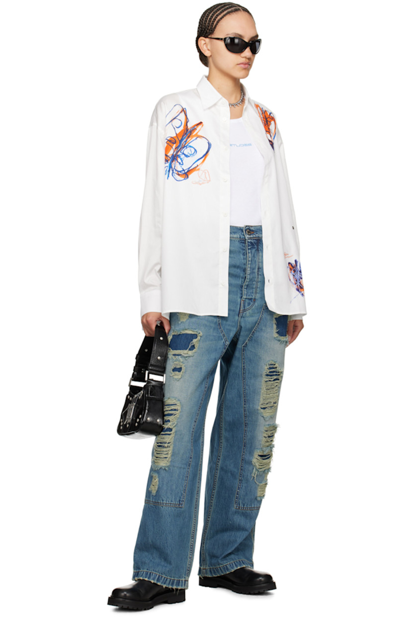 Organic cotton poplin shirt.

· Spread collar
· Button closure
· Graphics printed at front and back
· Logo-engraved silver-tone hardware at front
· Droptail hem
· Dropped shoulders
· Adjustable single-button barrel cuffs
· Pleats at cuffs

Part of the Études x Julian Farade collaboration.

Supplier color: Ete