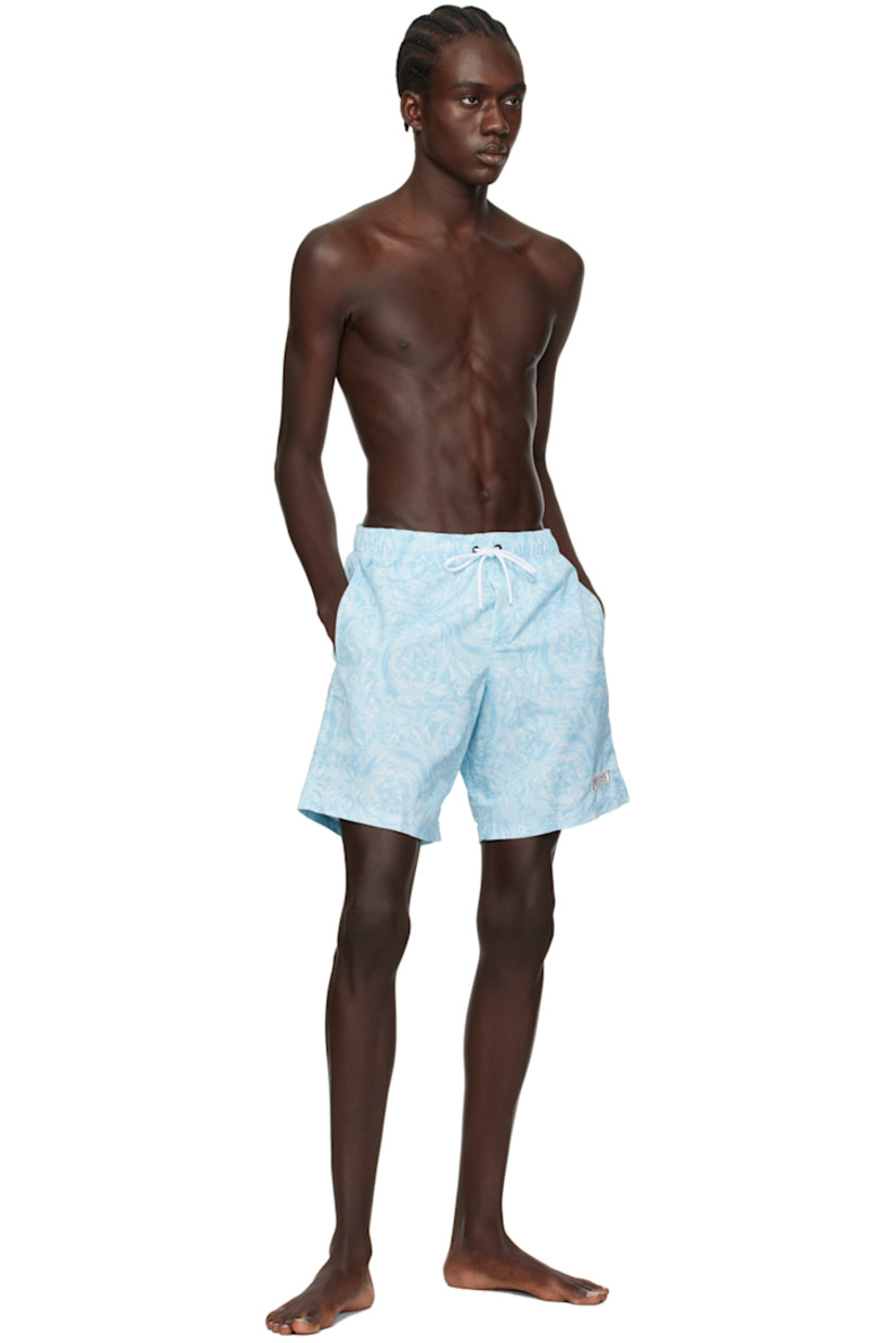 Polyester taffeta swim shorts. Barocco pattern printed throughout. 

· Drawstring at elasticized waistband 
· Three-pocket styling 
· Rubberized logo patch at front leg
· Mesh lining 

Supplier color: Pale blue