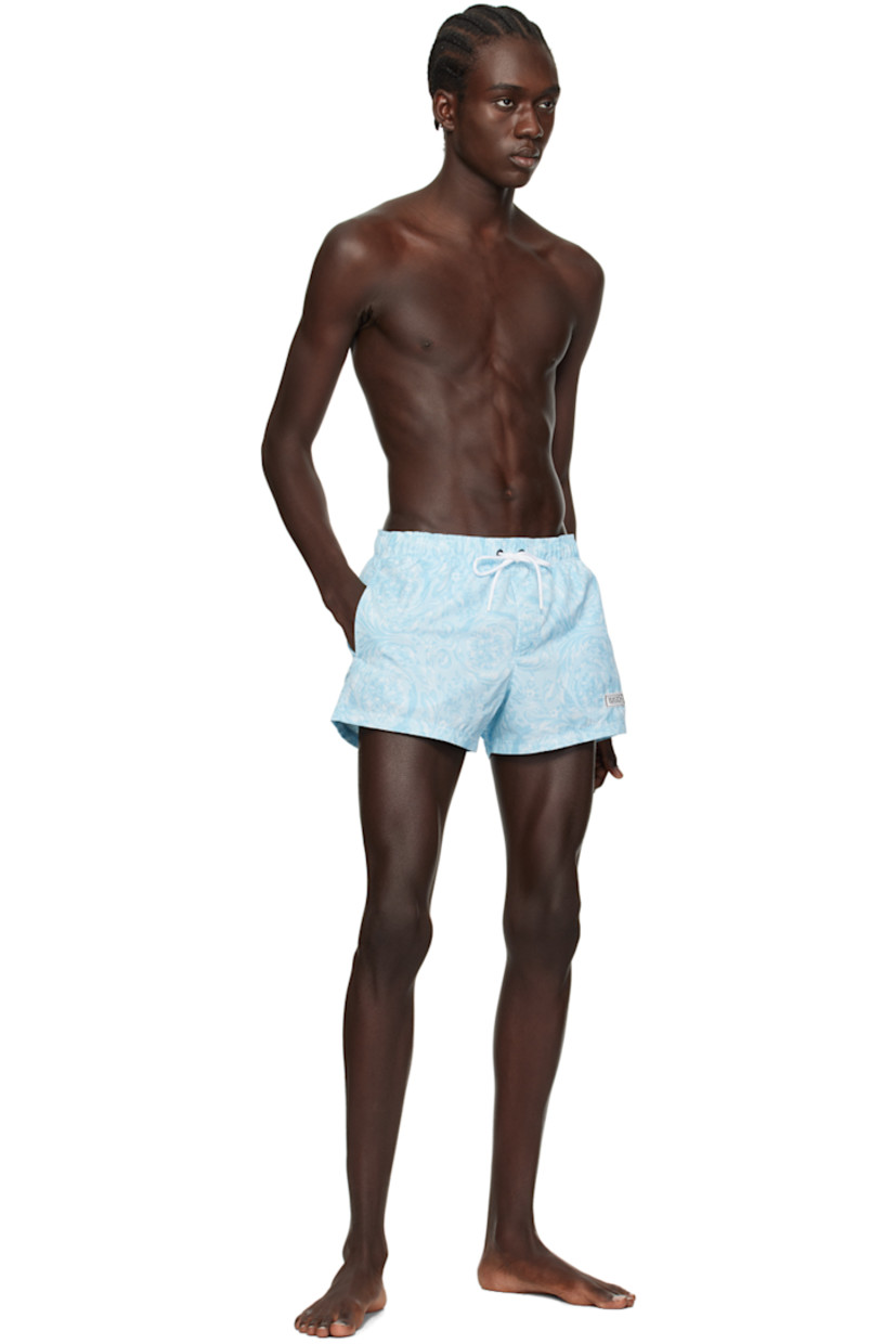 Polyester taffeta swim shorts. Barocco pattern printed throughout. 
 
· Drawstring at elasticized waistband 
· Three-pocket styling 
· Rubberized logo patch at front leg
· Mesh lining 

Supplier color: Pale blue