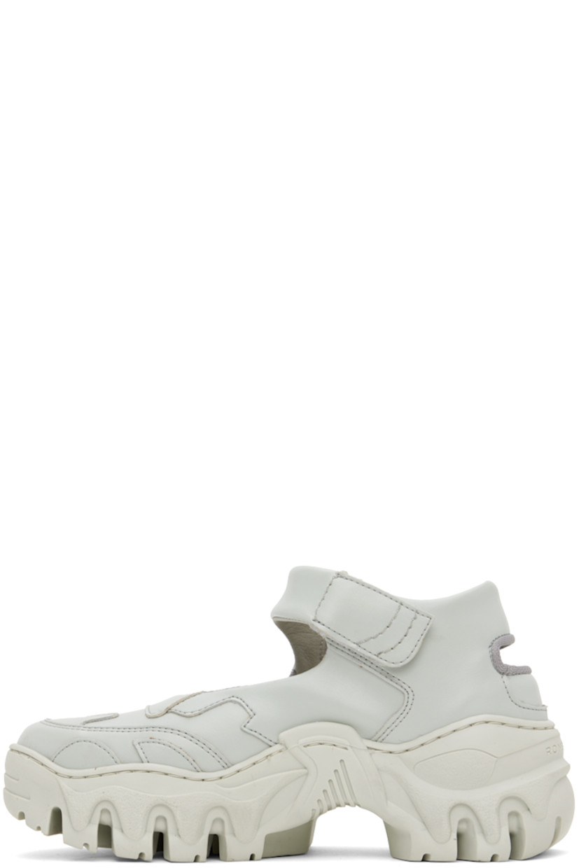 Handcrafted low-top paneled buffed faux-leather sneakers in gray.

· Velcro ankle strap
· Cutout at heel and outer side
· Mesh lining
· Treaded sculptural TPU platform sole
· Platform: H2"

Supplier color: Light grey