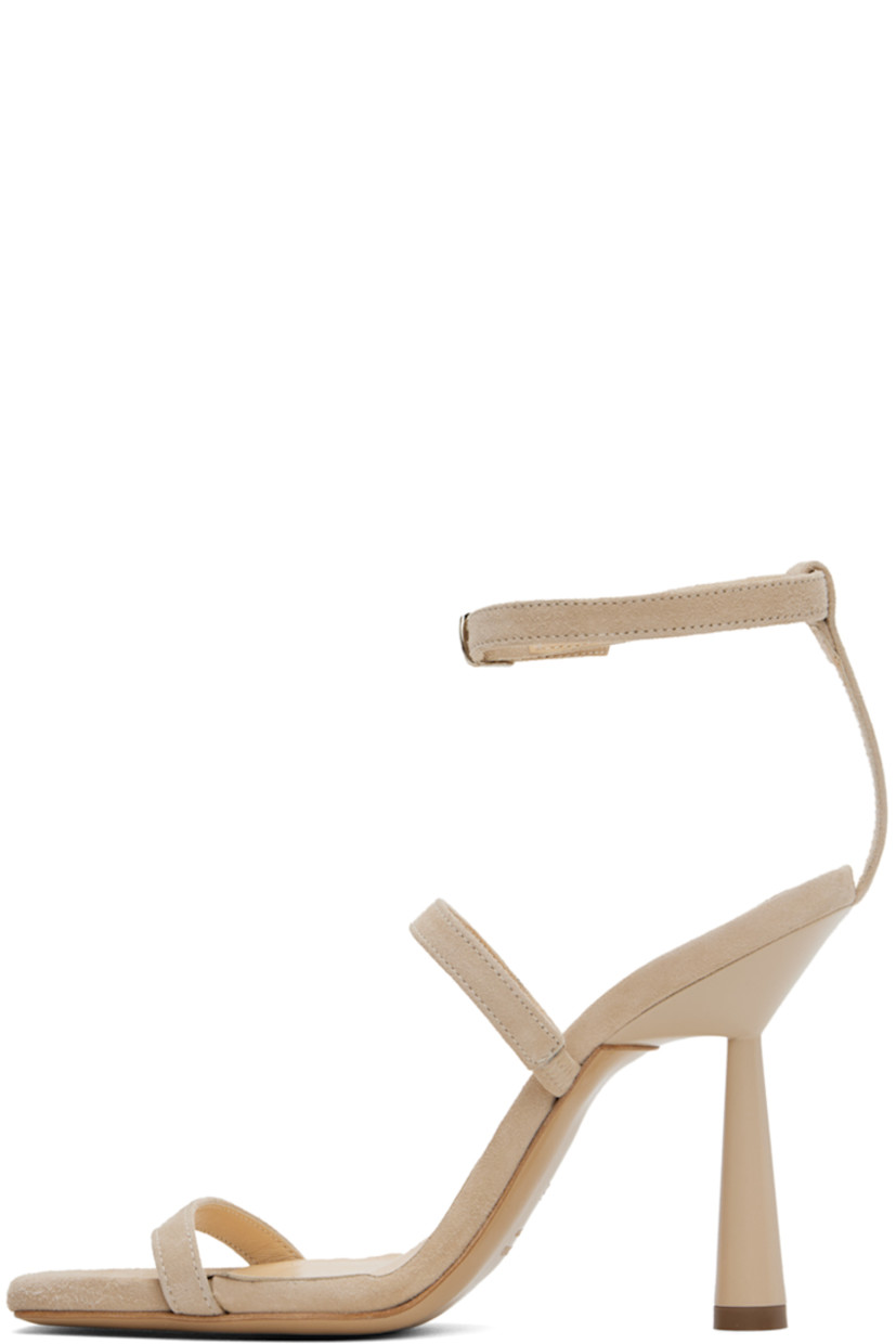 Suede heeled sandals in beige.

· Open square toe
· Straps at vamp
· Pin-buckle ankle strap
· Logo embossed at footbed
· Stiletto heel with rubber injection
· Leather sole
· Heel: H4"

Supplier color: Sand