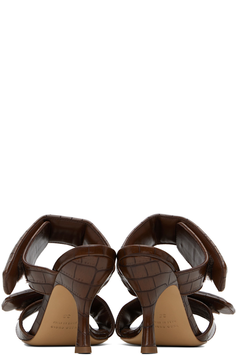 Croc-embossed faux-leather slip-on heeled sandals in brown.

· Open square toe
· Padded velcro straps at vamp
· Logo embossed at footbed
· Covered stiletto heel with rubber injection
· Leather sole
· Heel: H3.75"

Supplier color: Chocolate