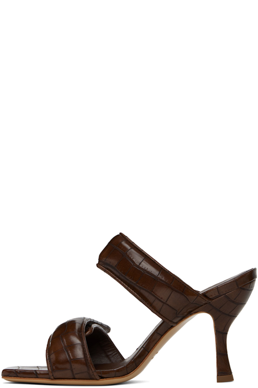 Croc-embossed faux-leather slip-on heeled sandals in brown.

· Open square toe
· Padded velcro straps at vamp
· Logo embossed at footbed
· Covered stiletto heel with rubber injection
· Leather sole
· Heel: H3.75"

Supplier color: Chocolate