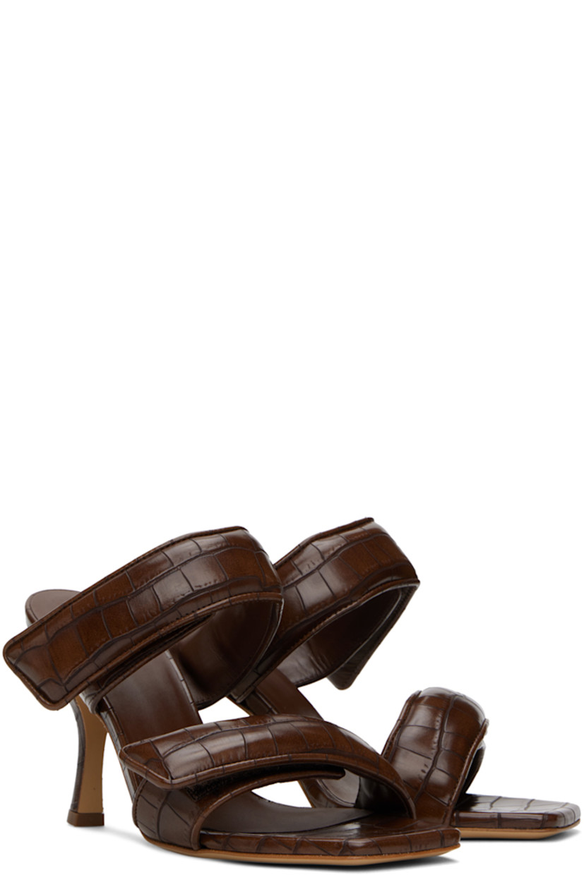 Croc-embossed faux-leather slip-on heeled sandals in brown.

· Open square toe
· Padded velcro straps at vamp
· Logo embossed at footbed
· Covered stiletto heel with rubber injection
· Leather sole
· Heel: H3.75"

Supplier color: Chocolate