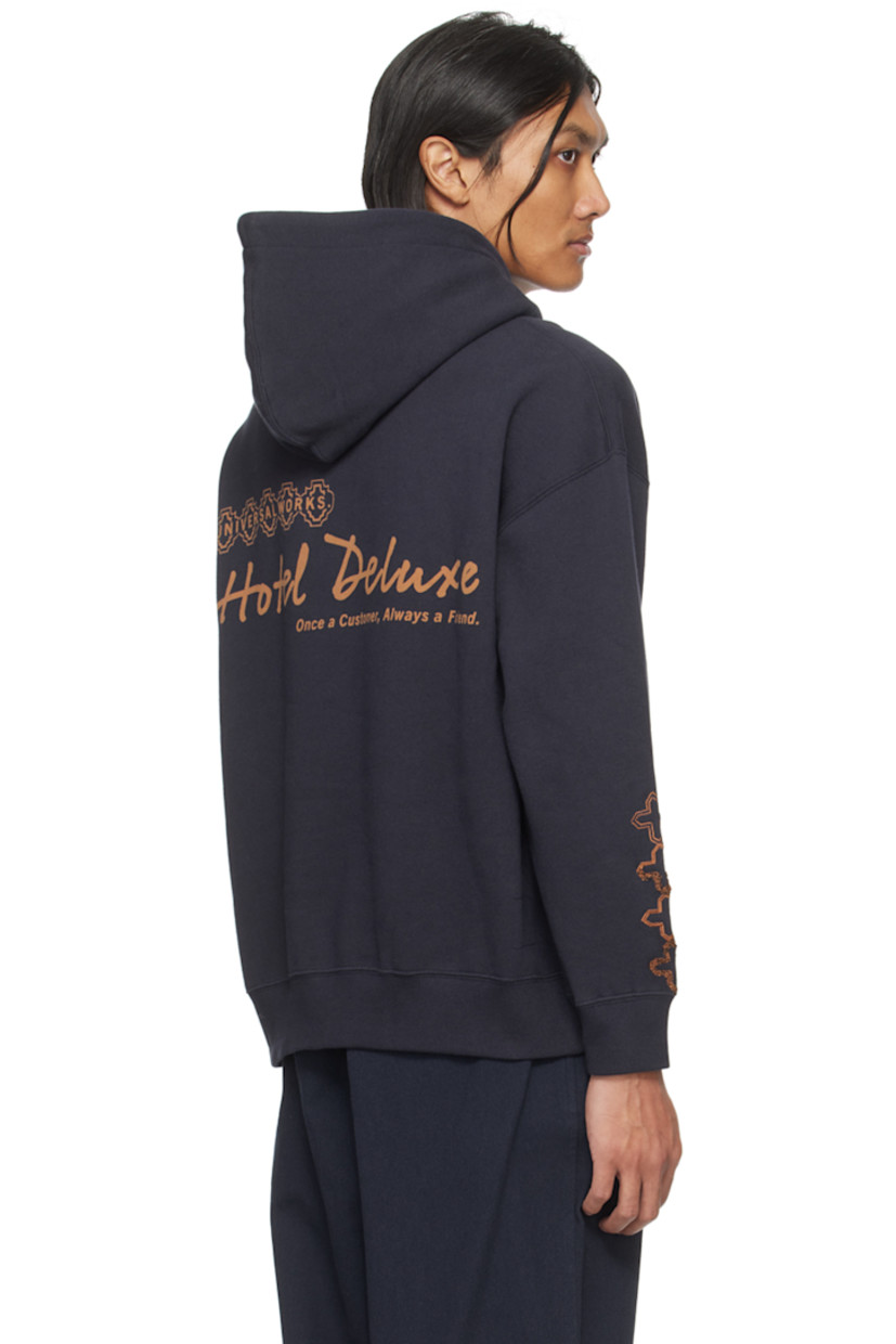 Cotton fleece hoodie.

· Logo printed at front
· Kangaroo pocket
· Rib knit hem and cuffs
· Graphic embroidered at sleeve
· Logo and text printed at back

Supplier color: Navy