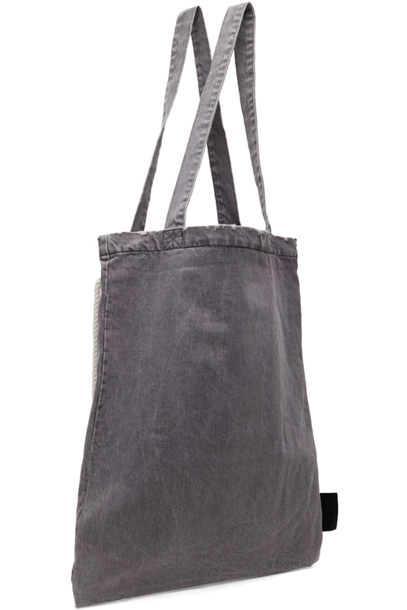 Stonewashed non-stretch denim tote in gray. 

· Distressing and subtle fading throughout
· Twin shoulder straps
· Cord accent at face
· Flap pocket 
· Logo flag at side
· Open throat
· Patch pocket at interior
· Full flannel lining 
· Contrast stitching in black
· H20.5" x W16.75" 

Supplier color: Dark grey