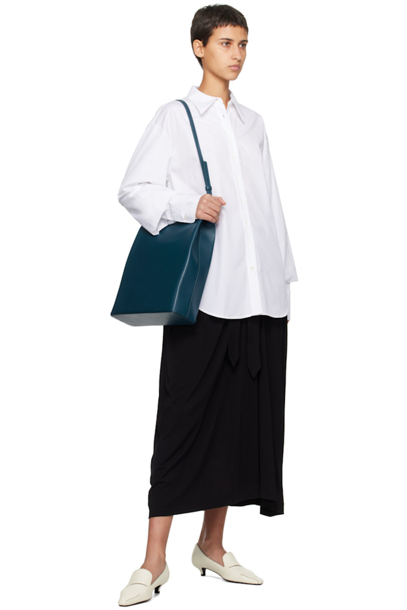 Cotton poplin shirt.

· Pointed collar
· Button closure
· Shirttail hem
· Gathering at bishop sleeves
· Single-button barrel cuffs

Supplier color: White
