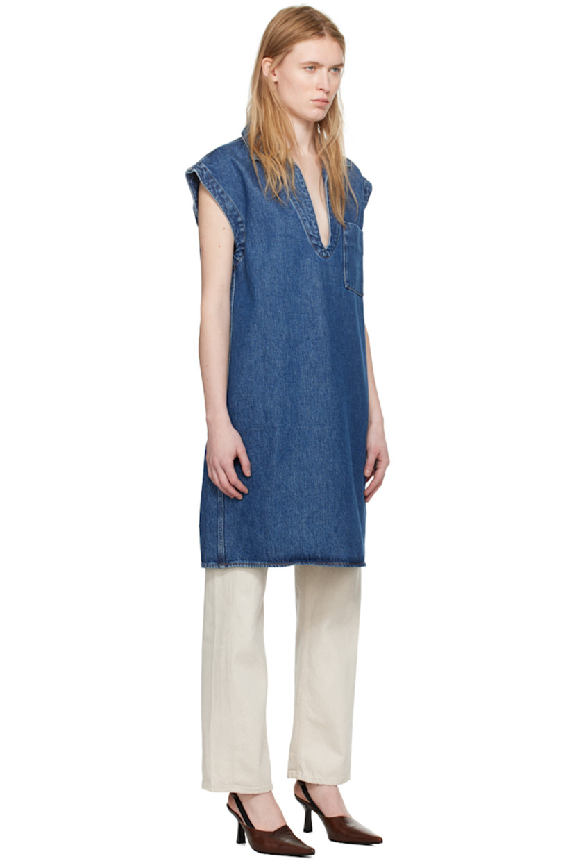 Non-stretch organic cotton denim blouse. 

· Open plunging spread collar
· Patch pocket 
· Cap sleeves
· Inverted box pleats at back yoke
· Contrast stitching in orange

Supplier color: Mid blue