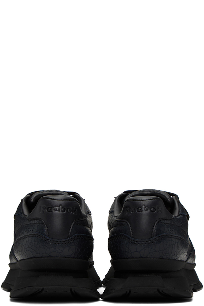 Low-top cracked leather sneakers in black. 

· Perforated detailing at toe and sides
· Lace-up closure
· Logo embossed at padded tongue
· Padded collar
· Logo flag at outer side
· Logo embossed at heel counter
· Grained leather and canvas lining
· Sculptural foam rubber midsole
· Treaded rubber outsole

Supplier color: Cracked black