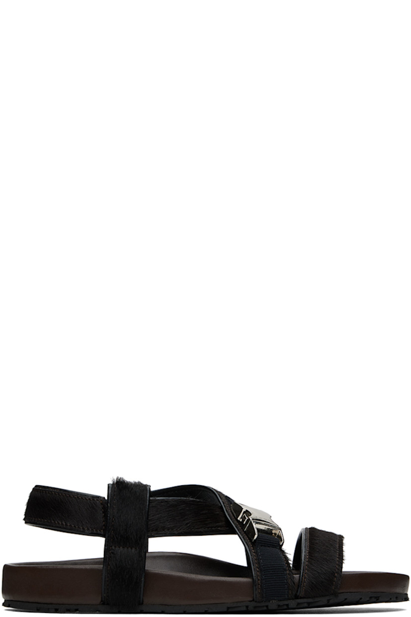 Calf-hair flat sandals in brown.

· Open toe
· Criss-crossing strap at vamp
· Logo-engraved press-release hardware at vamp
· Partially elasticized slingback strap 
· Logo stamp at molded leather footbed
· Treaded rubber sole

Supplier color: Dark brown