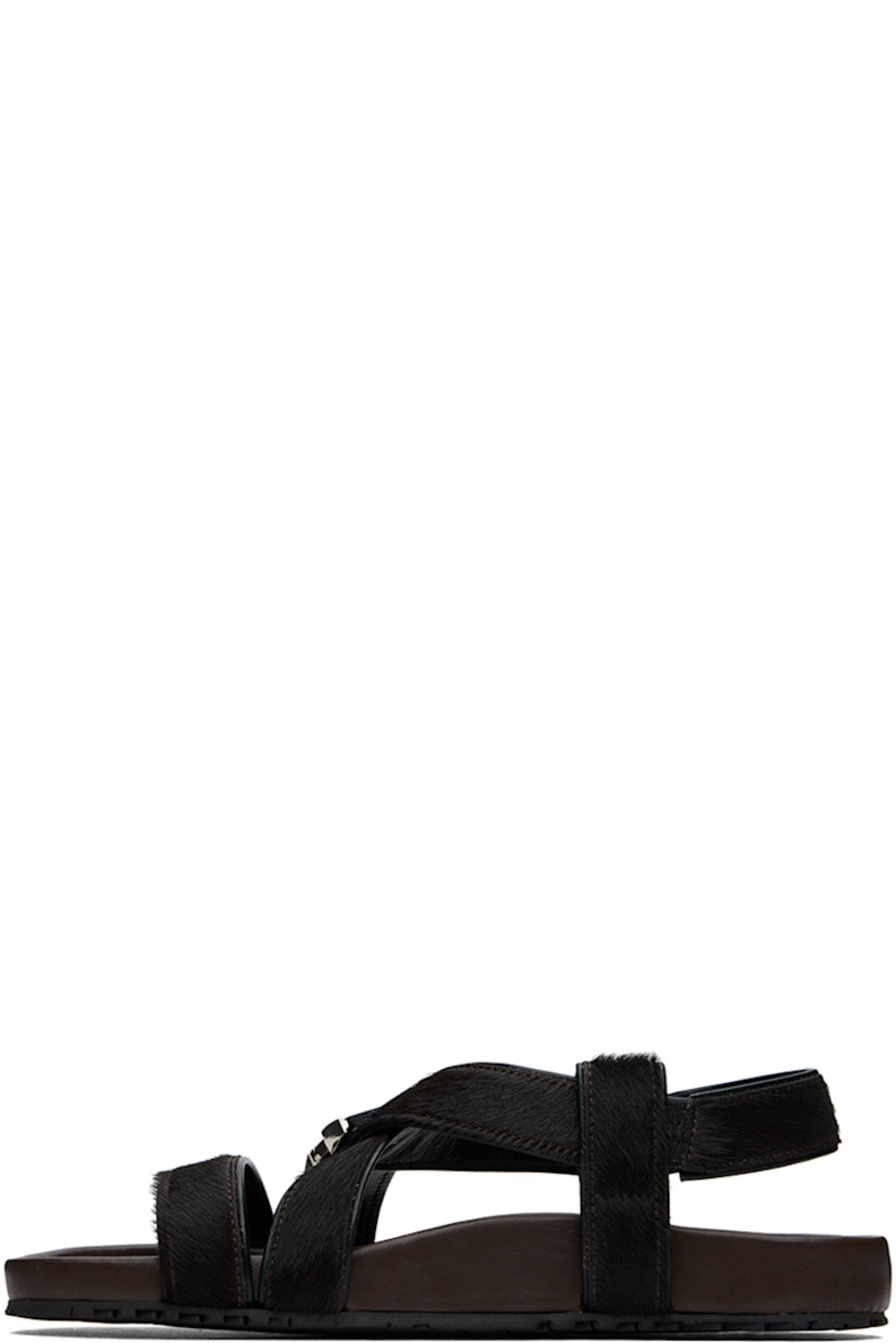 Calf-hair flat sandals in brown.

· Open toe
· Criss-crossing strap at vamp
· Logo-engraved press-release hardware at vamp
· Partially elasticized slingback strap 
· Logo stamp at molded leather footbed
· Treaded rubber sole

Supplier color: Dark brown