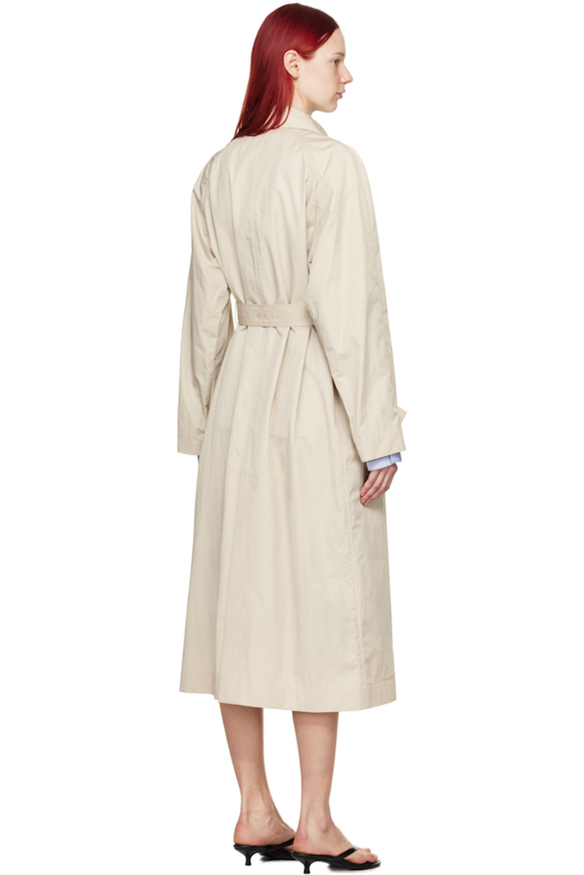 Crinkled cotton- and nylon-blend twill trench coat.

· Pin-buckle strap at spread collar
· Concealed button placket
· Pin-buckle belt at waist
· Welt pockets
· Raglan sleeves
· Button tab at cuffs
· Central vent at back hem
· Unlined

Supplier color: Light beige