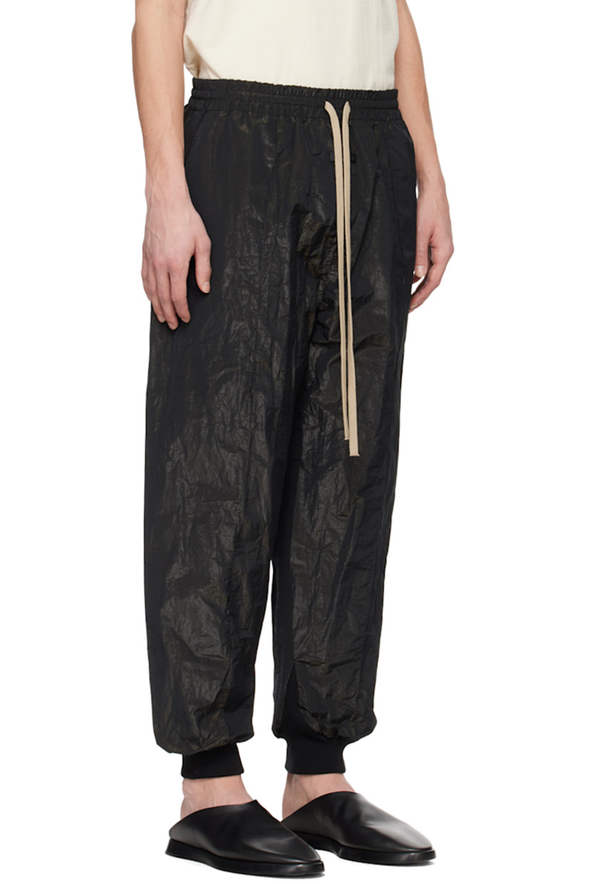 Crinkled polyester lamé taffeta track pants.

· Drawstring at elasticized waistband
· Two-pocket styling
· Leather logo patch at front
· Pintucks at legs  
· Rib knit cuffs

Supplier color: Black
