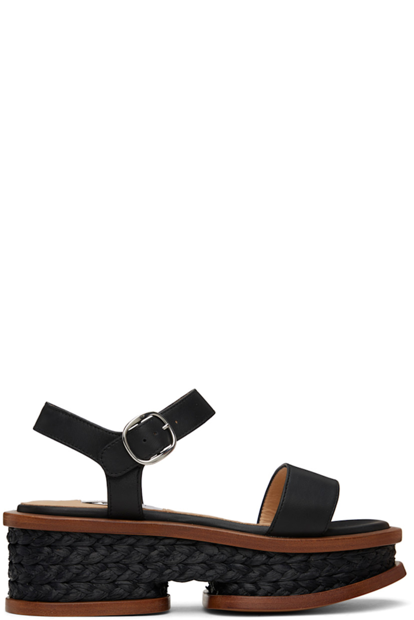Handcrafted buffed nappa lambskin sandals in black. 

· Hand-woven raffia trim throughout 
· Open pointed toe
· Strap at vamp
· Pin-buckle ankle strap
· Logo patch at padded footbed
· Buffed calfskin lining
· Platform wood midsole 
· Polished leather sole
· Platform: H2.5"

Supplier color: Black