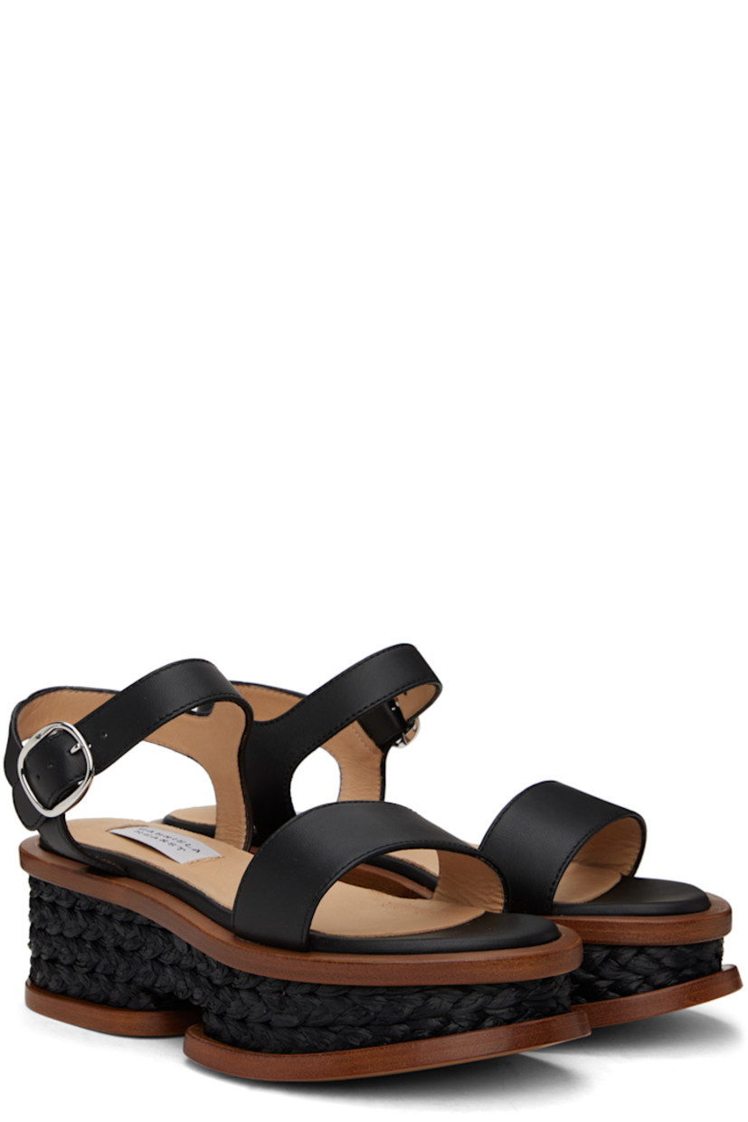Handcrafted buffed nappa lambskin sandals in black. 

· Hand-woven raffia trim throughout 
· Open pointed toe
· Strap at vamp
· Pin-buckle ankle strap
· Logo patch at padded footbed
· Buffed calfskin lining
· Platform wood midsole 
· Polished leather sole
· Platform: H2.5"

Supplier color: Black