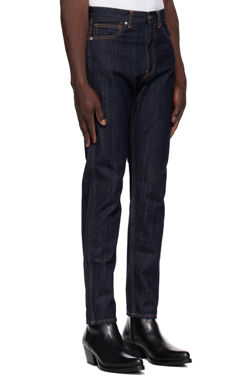 Tapered 11 oz non-stretch denim jeans.

· Belt loops
· Five-pocket styling
· Zip-fly
· Leather logo patch at back waistband
· Logo-engraved silver-tone hardware
· Contrast stitching in orange

Supplier color: Indigo