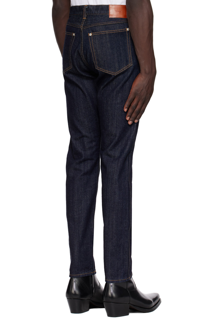 Tapered 11 oz non-stretch denim jeans.

· Belt loops
· Five-pocket styling
· Zip-fly
· Leather logo patch at back waistband
· Logo-engraved silver-tone hardware
· Contrast stitching in orange

Supplier color: Indigo