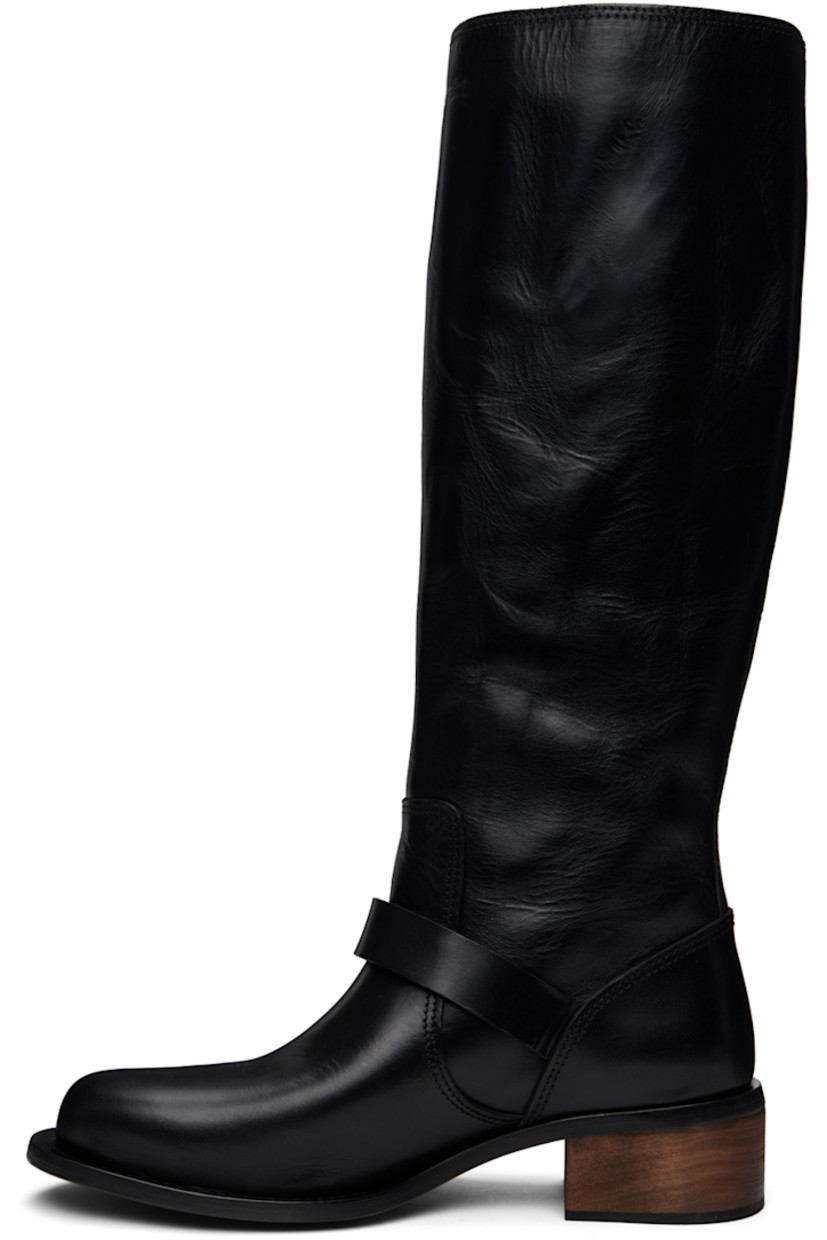 Calf-high grained horse leather boots in black.

· Pin-buckle strap at vamp
· Wood block heel with rubber injection 
· Leather sole
· Heel: H1.75"

Supplier color: Black