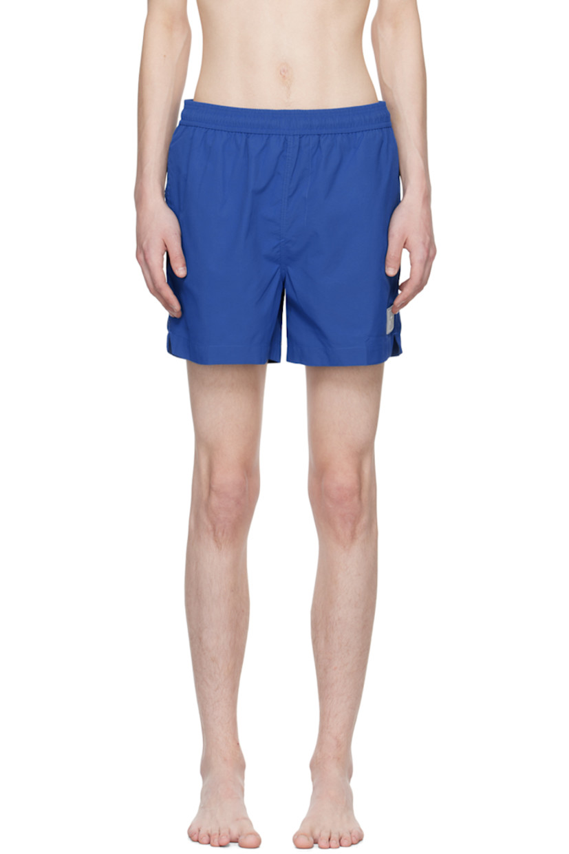 Nylon ripstop swim shorts. 

· Drawstring at elasticized waistband
· Three-pocket styling
· Mock-fly
· Rubberized logo patch at front
· Vented outseams
· Partial polyester mesh lining

Supplier color: Volt blue