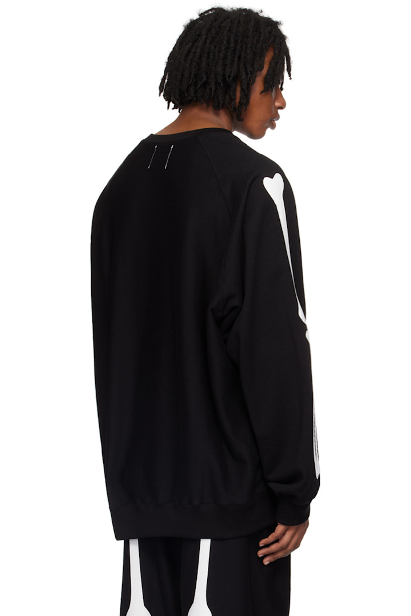 French terry sweatshirt.

· Rib knit crewneck, hem, and cuffs
· Graphic patch at chest
· Logo printed at front
· Graphic appliqués at raglan sleeves

Supplier color: Black/White