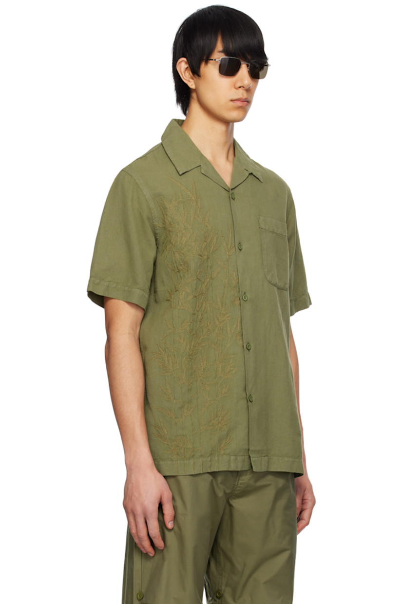 Lightweight hemp- and cotton-blend canvas shirt. Subtle distressing throughout.

· Open spread collar
· Button closure
· Patch pocket
· Hand-machined graphic embroidered at front
· Logo flag at side seam

Supplier color: Olive