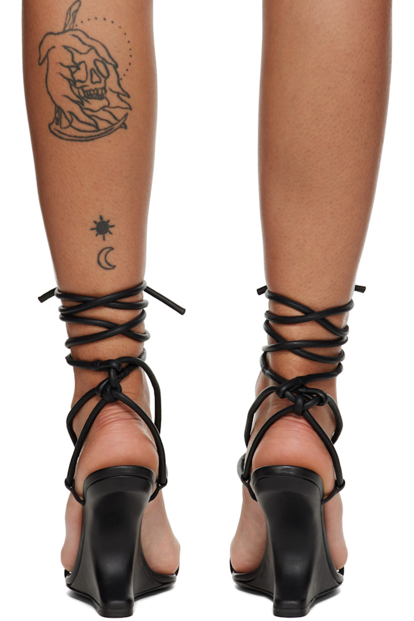 Grained lambskin heeled sandals in black.

· Open square toe
· Criss-crossing straps with knotted detailing at vamp
· Wraparound self-tie ankle strap
· Logo embossed at calfskin footbed
· Covered modified wedge heel
· Leather sole with TPU injection
· Heel: H4.5"

Supplier color: Black