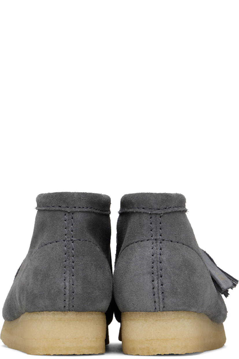 Ankle-high suede boots in gray.

· Square moc toe
· Logo tags and tassel at lace-up closure
· Bellows tongue
· Suede and grained sheepskin lining
· EVA rubber midsole
· FSC-certified crepe rubber sole
· Includes additional laces in gray

Supplier color: Grey/Blue suede