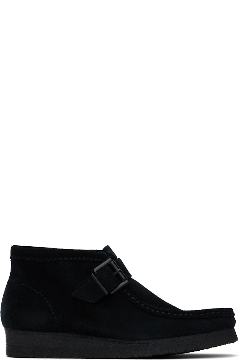 Ankle-high suede boots in black.

· Hand-stitched detailing at square moc toe
· Pin-buckle strap at vamp
· Bellows tongue
· Suede lining
· EVA rubber midsole
· FSC-certified crepe rubber sole

Supplier color: Black suede