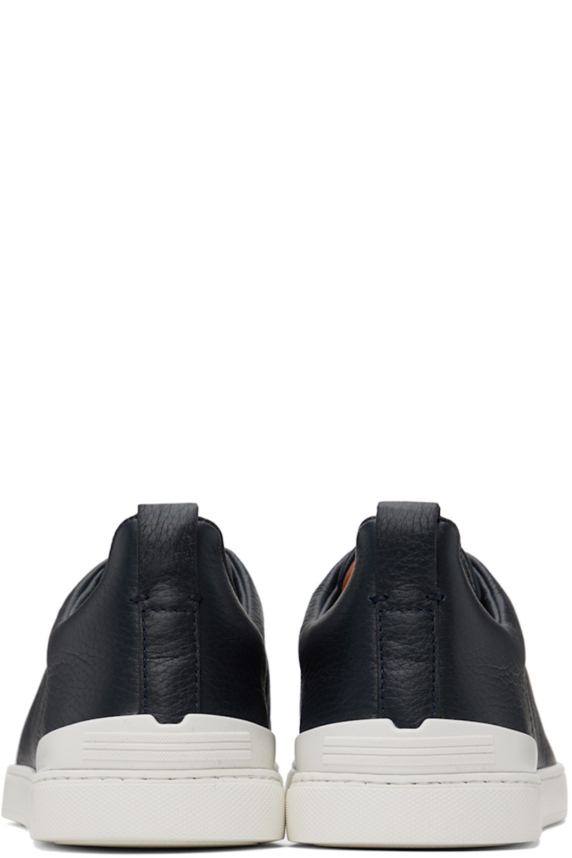 Low-top grained deerskin sneakers in navy.

· Elasticized criss-crossing straps at vamp
· Logo embossed at padded tongue
· Padded collar
· Pull-loop at heel tab
· Rubberized logo patch at heel counter
· Removable cushioned Sanitized® insole
· Buffed leather lining
· Treaded rubber sole

Supplier color: Navy blue