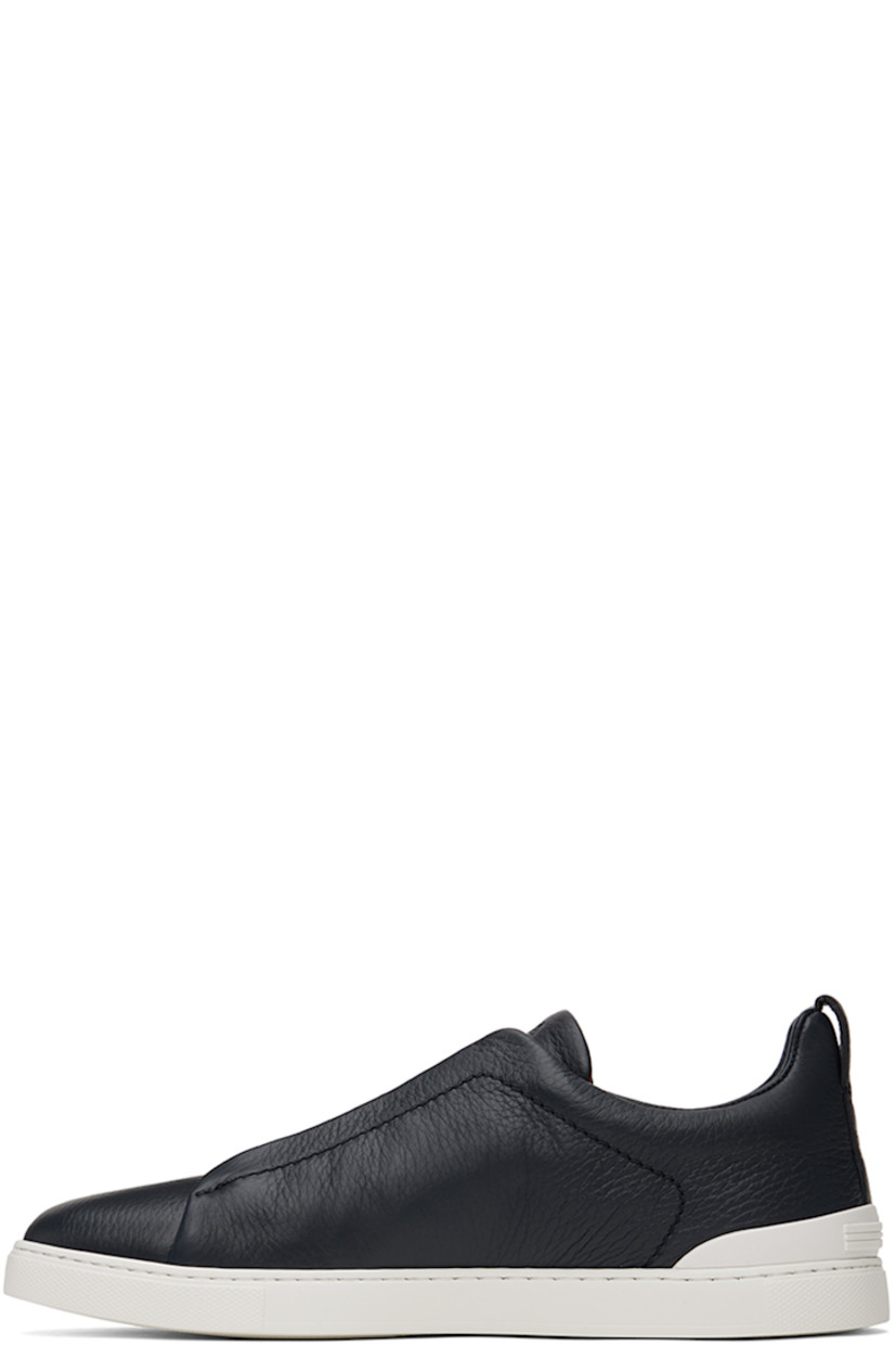 Low-top grained deerskin sneakers in navy.

· Elasticized criss-crossing straps at vamp
· Logo embossed at padded tongue
· Padded collar
· Pull-loop at heel tab
· Rubberized logo patch at heel counter
· Removable cushioned Sanitized® insole
· Buffed leather lining
· Treaded rubber sole

Supplier color: Navy blue