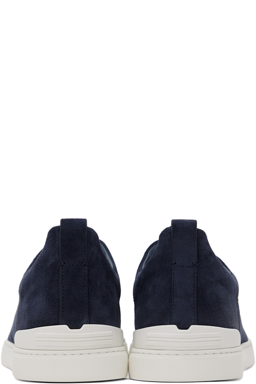 Low-top suede sneakers in blue.

· Elasticized criss-crossing straps at vamp
· Logo embossed at padded tongue
· Padded collar
· Pull-loop at heel tab
· Rubberized logo patch at heel counter
· Removable cushioned Sanitized® insole
· Buffed leather lining
· Treaded rubber sole

Supplier color: Utility blue