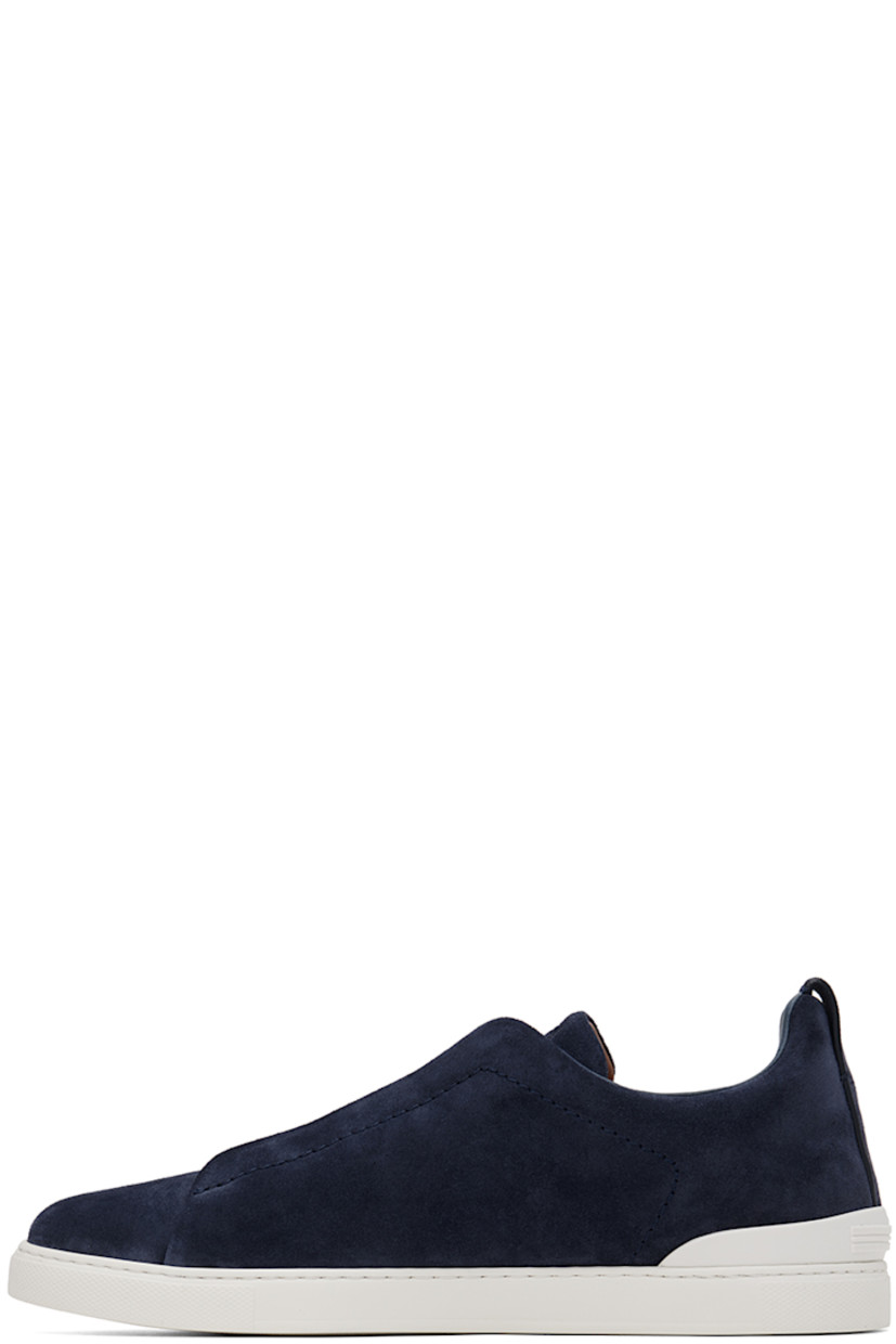 Low-top suede sneakers in blue.

· Elasticized criss-crossing straps at vamp
· Logo embossed at padded tongue
· Padded collar
· Pull-loop at heel tab
· Rubberized logo patch at heel counter
· Removable cushioned Sanitized® insole
· Buffed leather lining
· Treaded rubber sole

Supplier color: Utility blue
