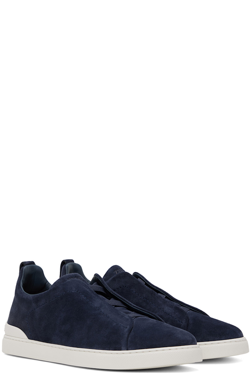 Low-top suede sneakers in blue.

· Elasticized criss-crossing straps at vamp
· Logo embossed at padded tongue
· Padded collar
· Pull-loop at heel tab
· Rubberized logo patch at heel counter
· Removable cushioned Sanitized® insole
· Buffed leather lining
· Treaded rubber sole

Supplier color: Utility blue