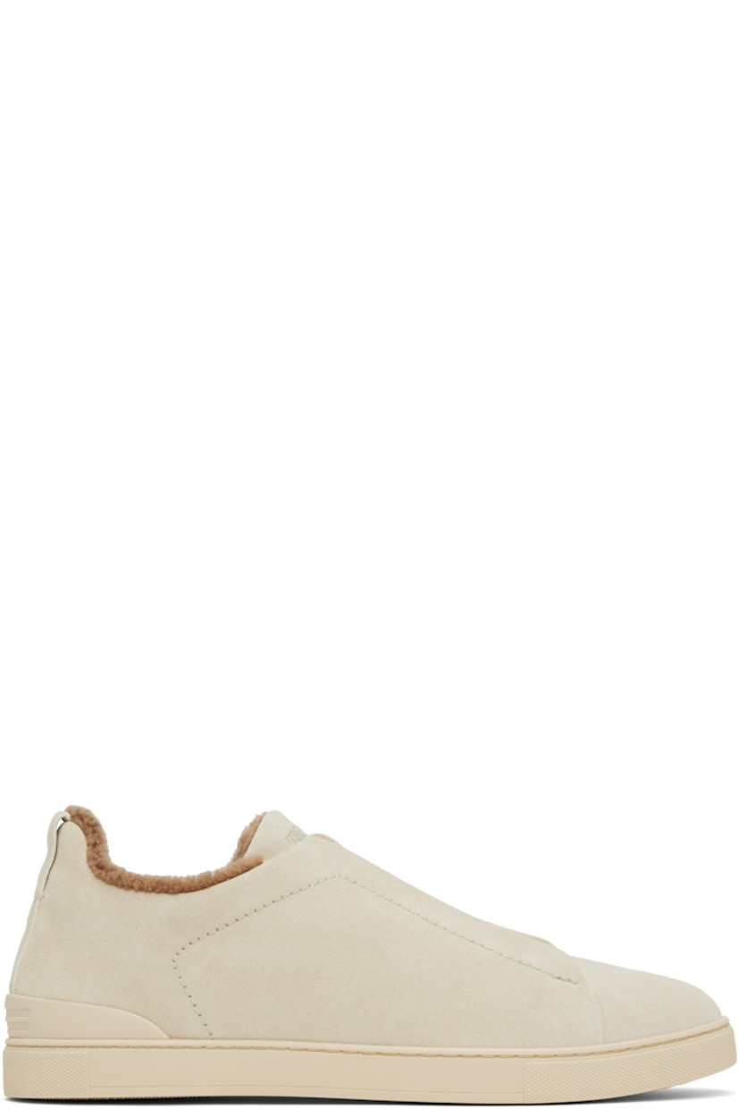 Low-top suede sneakers in gray.

· Elasticized criss-crossing straps at vamp
· Logo embossed at padded tongue
· Padded collar
· Pull-loop at heel
· Sanitized® footbed
· Wool sherpa fleece lining
· Treaded rubber sole

Supplier color: Light beige