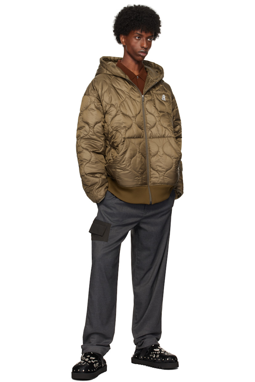 Padded and quilted polyester satin jacket.

· Hood at collar
· Zip closure
· Embroidered logo patch at chest
· Patch pockets
· Rib knit hem
· Thumbhole at inset jersey cuffs
· Locker loop at back collar
· Full satin lining

Supplier color: Brown