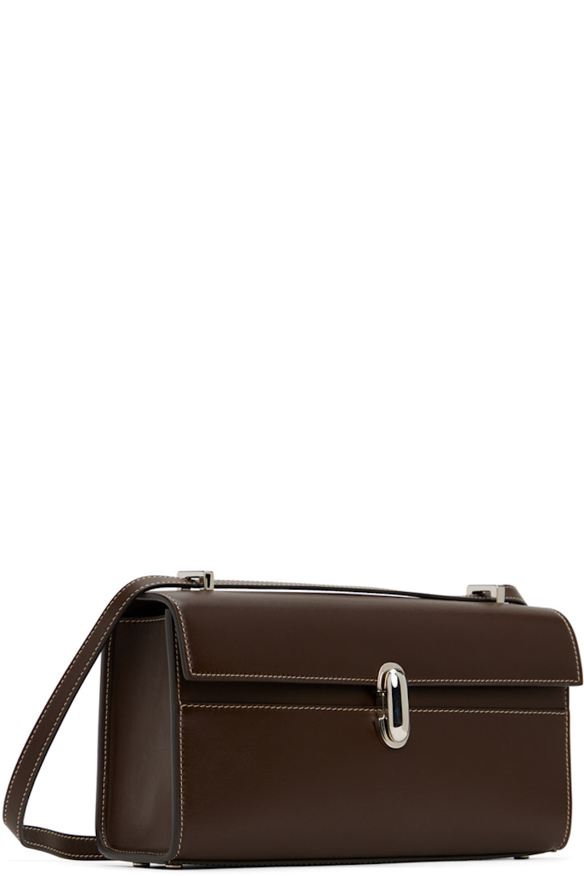 Buffed calfskin shoulder bag in brown.

· Convertible crossbody strap
· Bumper studs at base
· Turn-lock flap
· Patch pocket at interior
· Contrast stitching in off-white
· H5.5" x W10" x D2.25"

Supplier color: Coffee