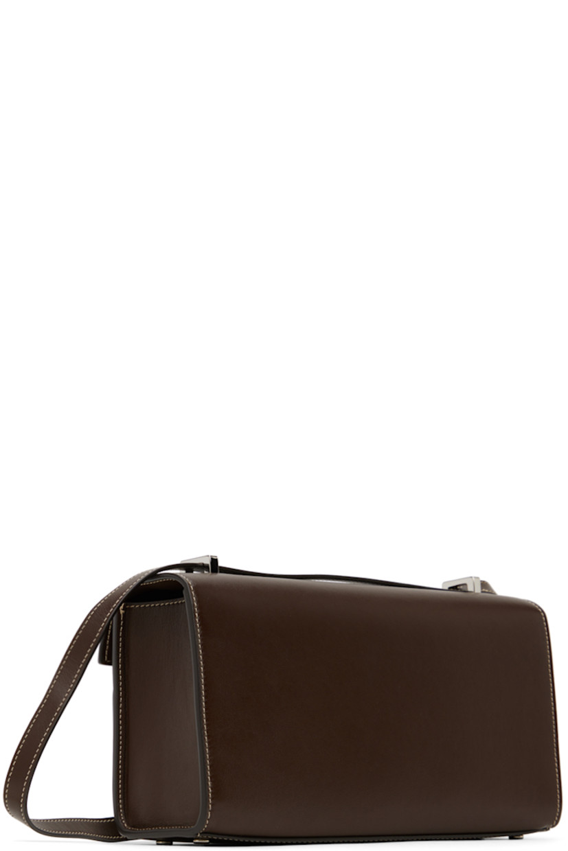 Buffed calfskin shoulder bag in brown.

· Convertible crossbody strap
· Bumper studs at base
· Turn-lock flap
· Patch pocket at interior
· Contrast stitching in off-white
· H5.5" x W10" x D2.25"

Supplier color: Coffee