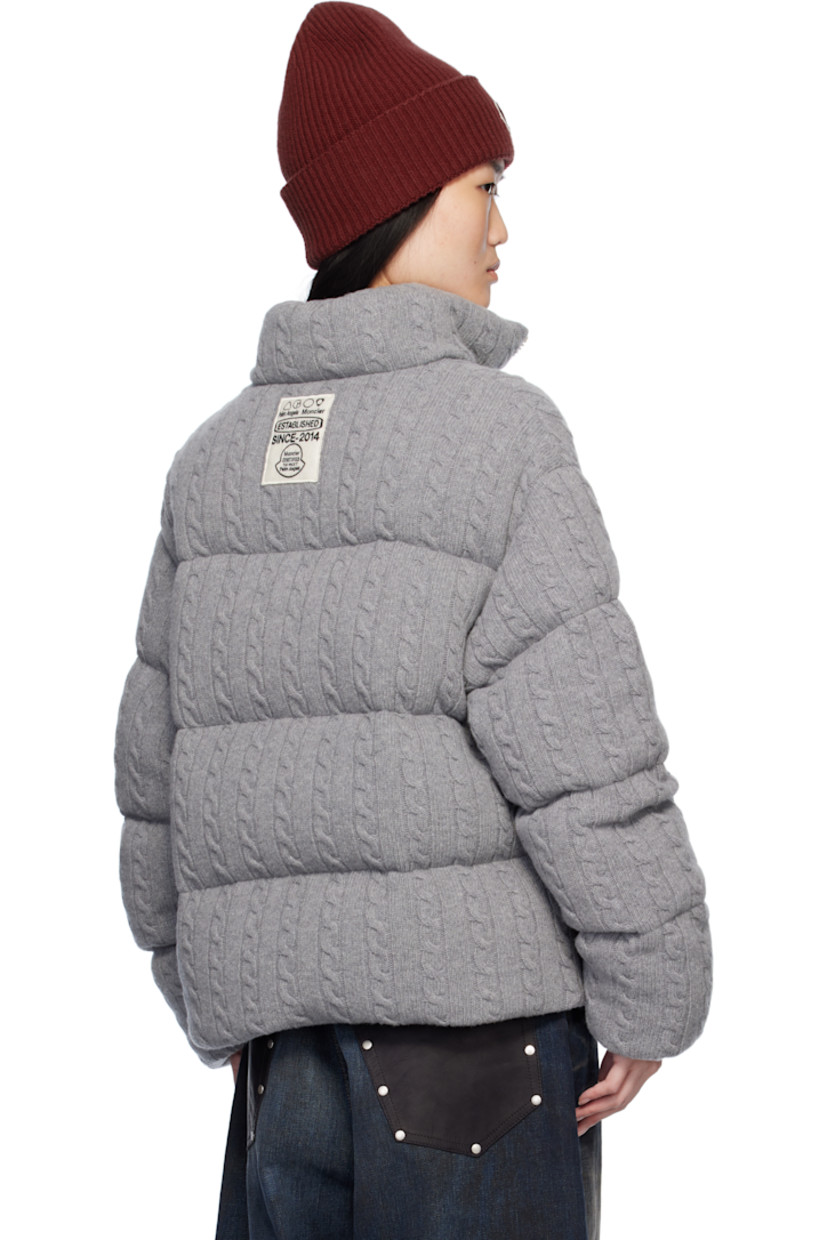 Down-filled and quilted cable knit virgin wool jacket.

· DIST-certified down
· Funnel neck
· Zip closure
· Logo appliqué at chest and back 
· Zip pockets
· Concealed bungee-style drawstring at hem
· Elasticized cuffs
· Full nylon satin lining
· Logo-engraved silver-tone hardware

Part of the Moncler Genius x Palm Angels collaboration.

Supplier color: Gray

Down: 90% down, 10% feather.