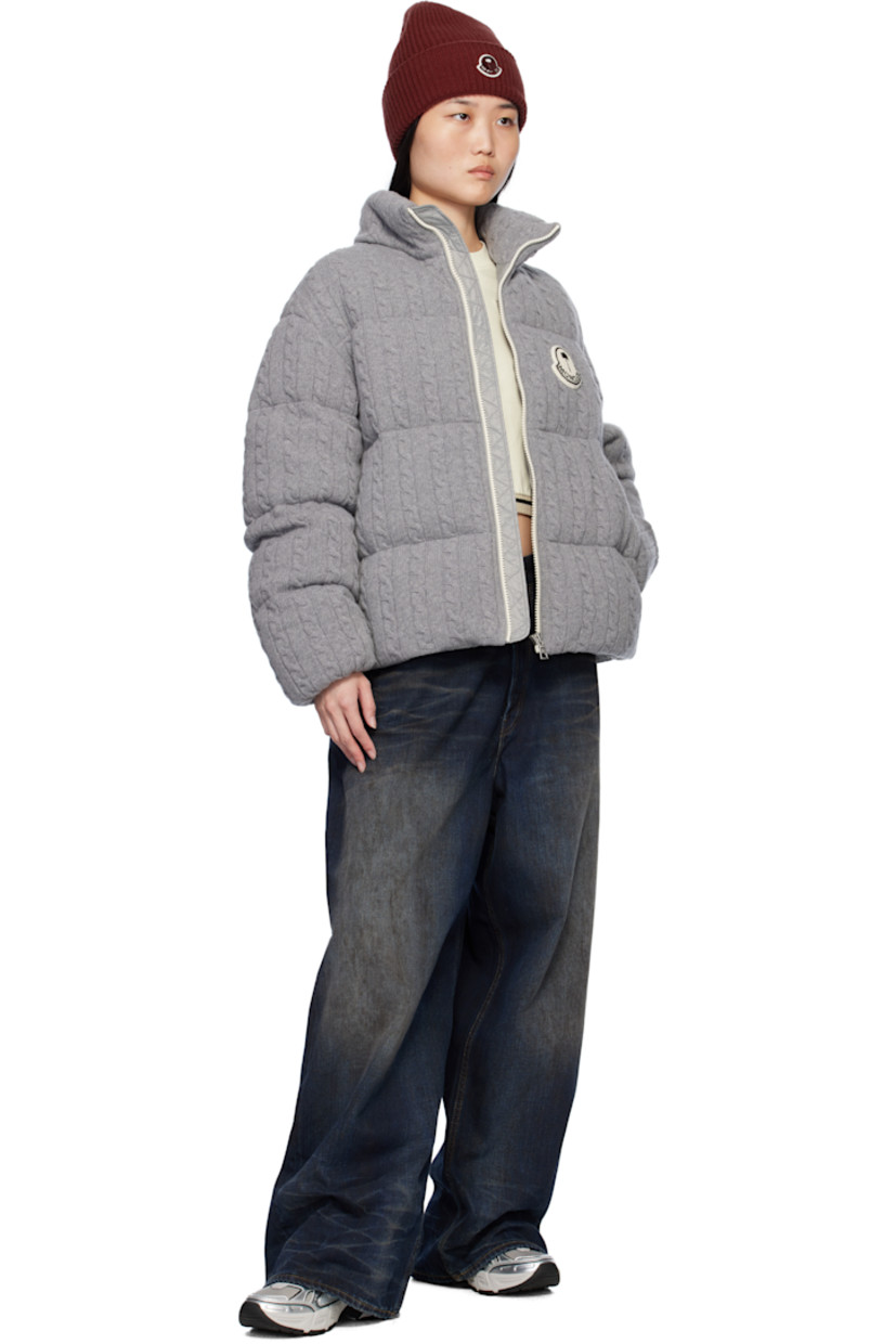 Down-filled and quilted cable knit virgin wool jacket.

· DIST-certified down
· Funnel neck
· Zip closure
· Logo appliqué at chest and back 
· Zip pockets
· Concealed bungee-style drawstring at hem
· Elasticized cuffs
· Full nylon satin lining
· Logo-engraved silver-tone hardware

Part of the Moncler Genius x Palm Angels collaboration.

Supplier color: Gray

Down: 90% down, 10% feather.