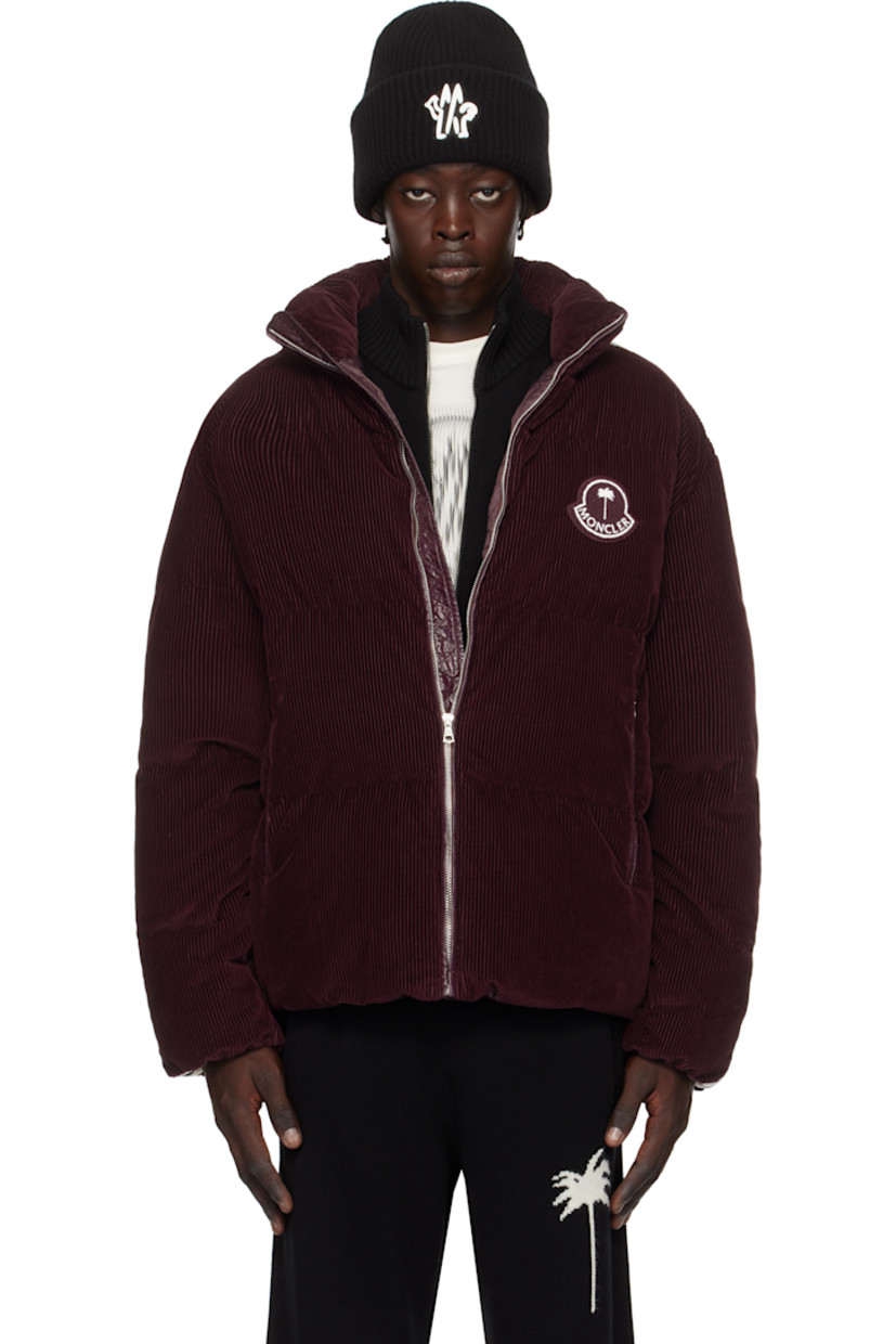 Down-filled quilted cotton corduroy jacket.

· DIST-certified down
· Stand collar
· Zip closure 
· Bouclé logo patch at chest
· Zip pockets
· Bungee-style drawstring at hem
· Striped knit trim at sleeves
· Elasticized cuffs
· Full nylon satin lining

Part of the Moncler Genius x Palm Angels collaboration.

Supplier color: Maroon

Fill: 90% goose down, 10% feather.