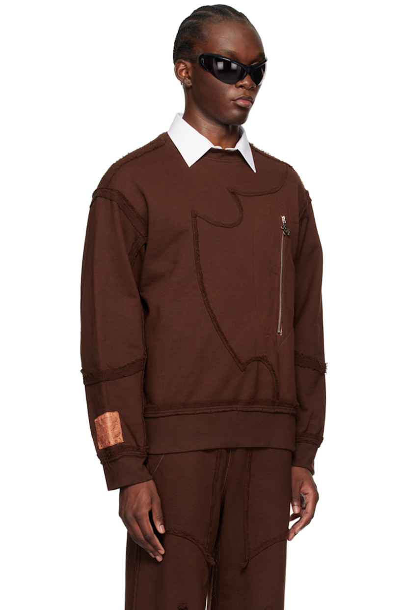 French terry sweatshirt. Exposed seams and raw edges throughout.

· Paneled construction
· Rib knit crewneck, hem, and cuffs
· Zip pocket and graphic charm at front
· Logo patch at cuff

Available exclusively at SSENSE.

Supplier color: Brown