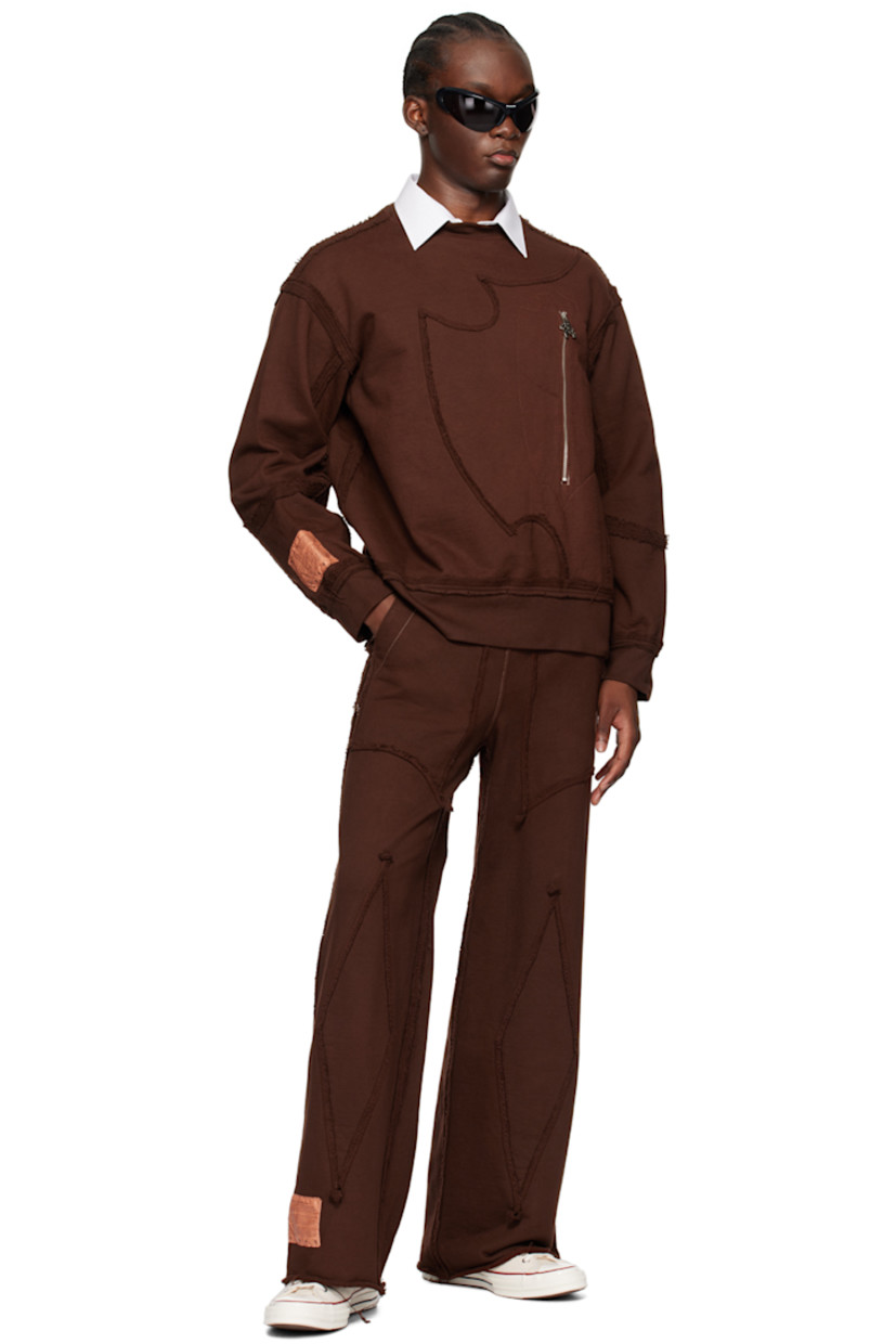 French terry sweatshirt. Exposed seams and raw edges throughout.

· Paneled construction
· Rib knit crewneck, hem, and cuffs
· Zip pocket and graphic charm at front
· Logo patch at cuff

Available exclusively at SSENSE.

Supplier color: Brown