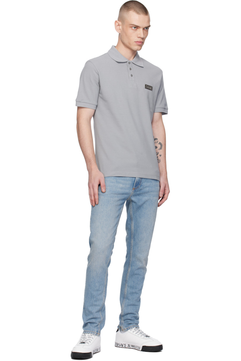 Slim-fit cotton piqué polo. 

·  Rib-knit spread collar and cuffs 
· Three-button placket
· Silver-tone logo plaque at chest
· Tennis-tail hem

Supplier color: Grey