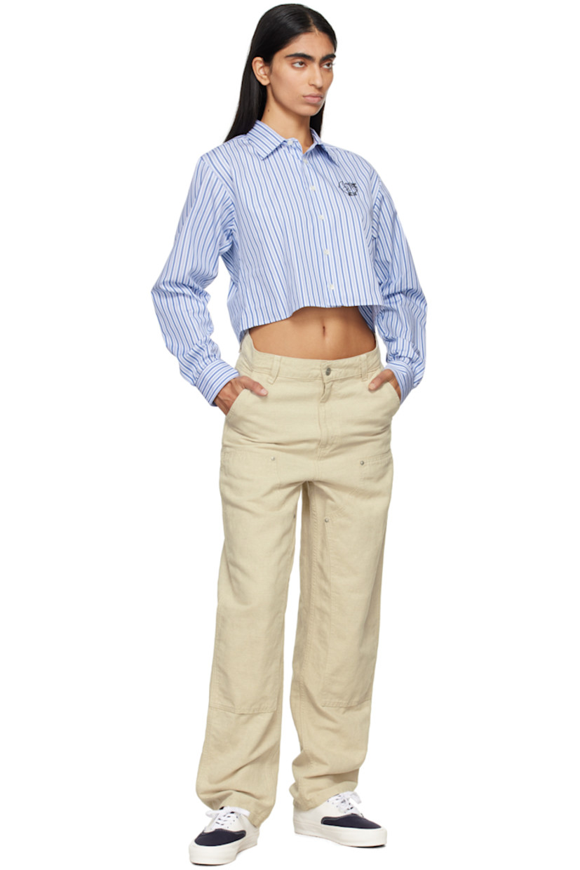 Deadstock cotton poplin shirt. Stripes throughout.

· Spread collar
· Button closure
· Logo graphic embroidered at chest 
· Cropped hem
· Single-button barrel cuffs
· Box pleat at back yoke

Supplier color: Blue stripe
