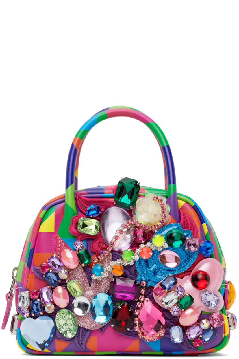 Buffed leather top handle bag in multicolor. Graphic printed, crystal-cut accents, and graphic appliqués throughout.

· Rolled carry handles
· Zip closure
· Patch pocket at interior
· Canvas lining
· H5" x W7" x D2"

Supplier color: Multi