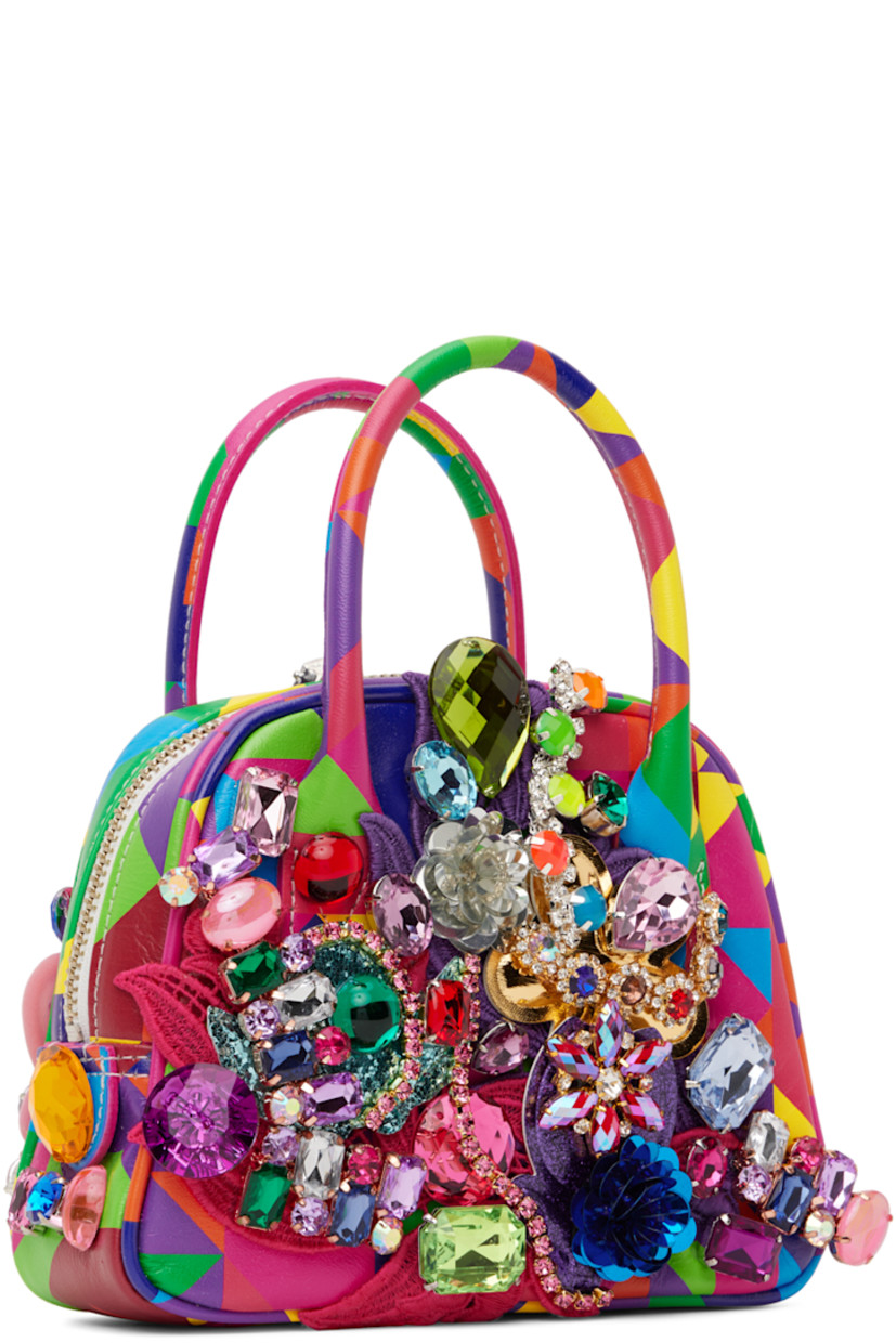 Buffed leather top handle bag in multicolor. Graphic printed, crystal-cut accents, and graphic appliqués throughout.

· Rolled carry handles
· Zip closure
· Patch pocket at interior
· Canvas lining
· H5" x W7" x D2"

Supplier color: Multi
